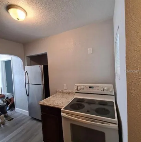 a kitchen with a stove top oven and refrigerator