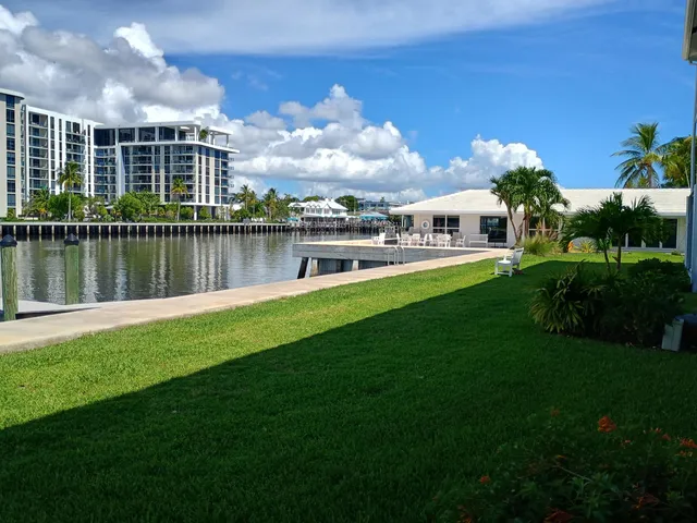 a view of a house next to a lake with a big yard