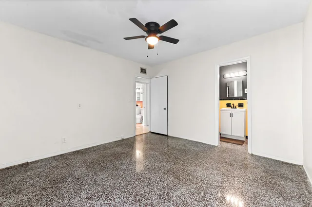 an empty room with closet and windows