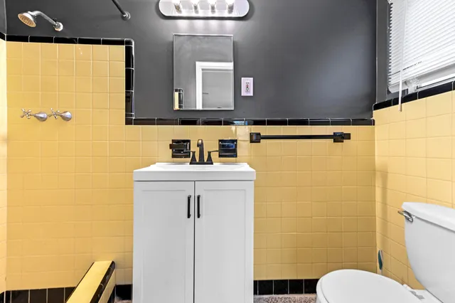 a bathroom with a toilet a sink and mirror