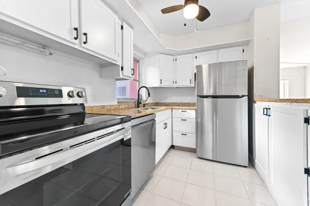 a kitchen with a refrigerator a sink and cabinets