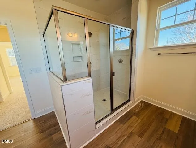 a bathroom with a glass door shower and a sink