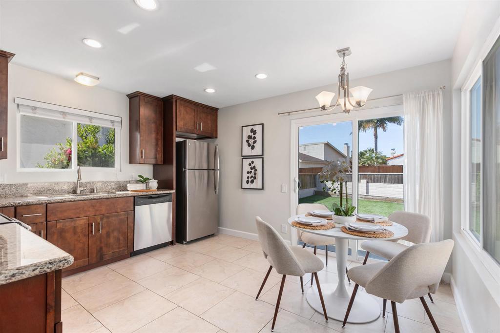 810 Caminito Del Mar Carlsbad, CA 92011 - Photo 9 of 30 a kitchen with granite countertop stainless steel appliances a table and chairs in it