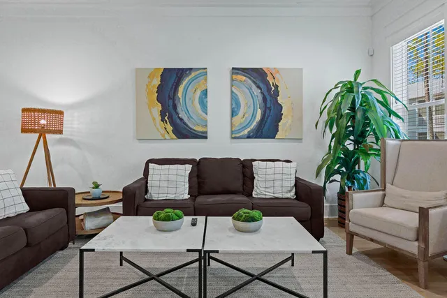 a living room with furniture and a wooden floor