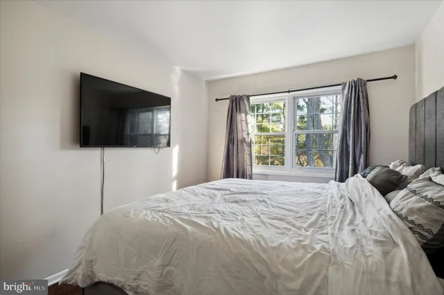 a bedroom with a bed tv and a window