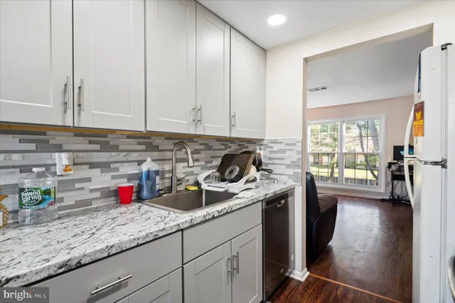 a kitchen with stainless steel appliances granite countertop a sink a stove and cabinets
