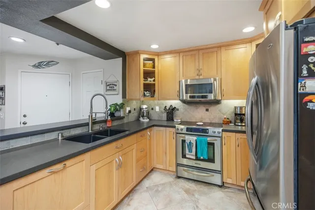a kitchen with stainless steel appliances granite countertop a stove a sink and a refrigerator