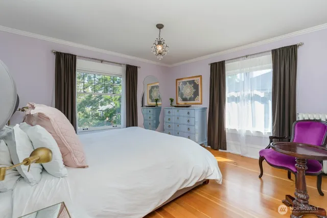 a spacious bedroom with a bed and wooden floor