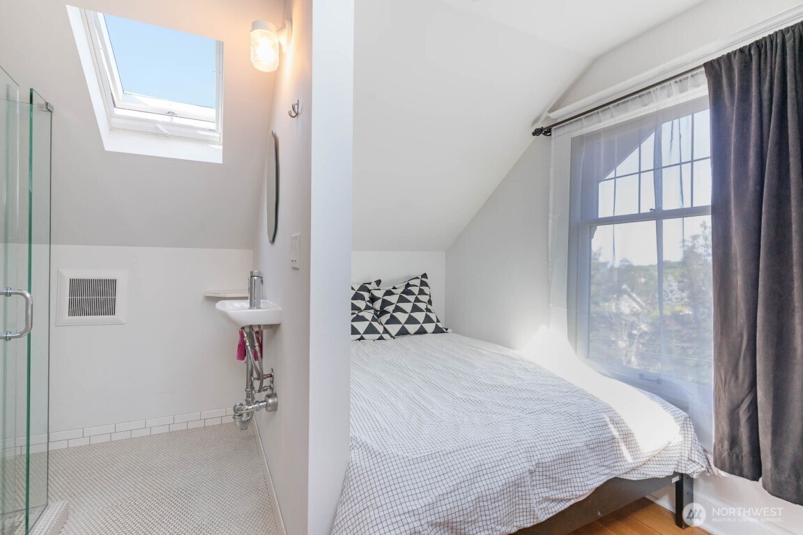 1607 6th Avenue West Seattle, WA 98119 - Photo 18 of 27 a bedroom with a bed and a window