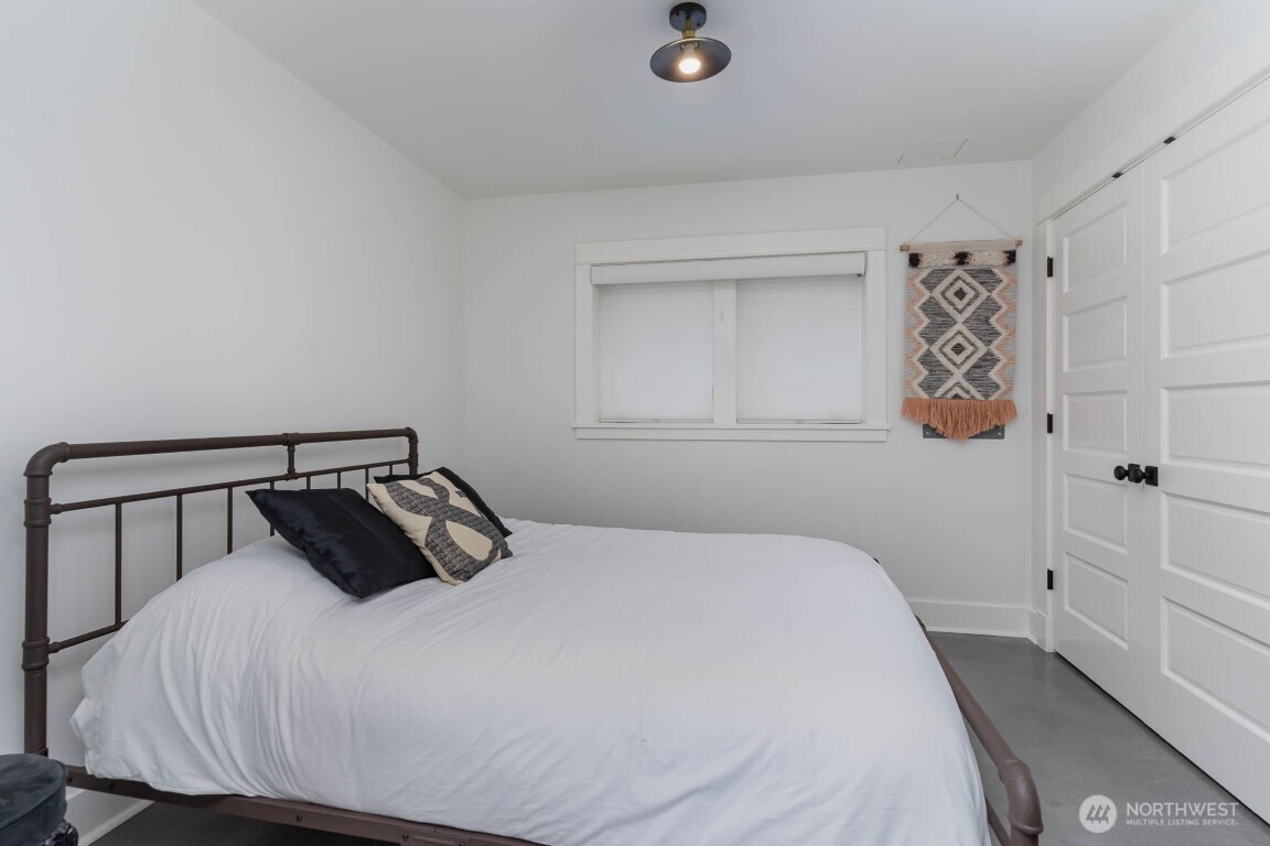 1607 6th Avenue West Seattle, WA 98119 - Photo 23 of 27 a bedroom with a bed and painting on the wall