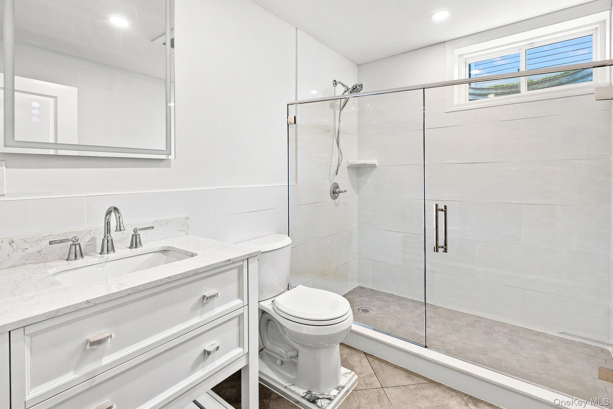 148 Latham Road Mineola, NY 11501 - Photo 26 of 27 Lower level bath with white vanity with an integrated rectangular sink, chrome fixtures, and white countertop.