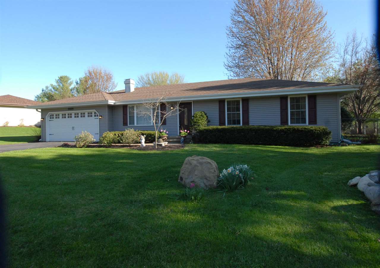 5525 Rural Edge Drive Roscoe, IL 61073 - Photo 1 of 21 a front view of a house with a garden and trees