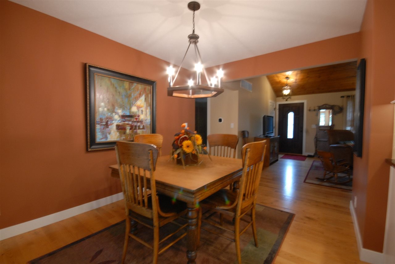 5525 Rural Edge Drive Roscoe, IL 61073 - Photo 9 of 21 a dining room with wooden floor a chandelier a wooden table and chairs