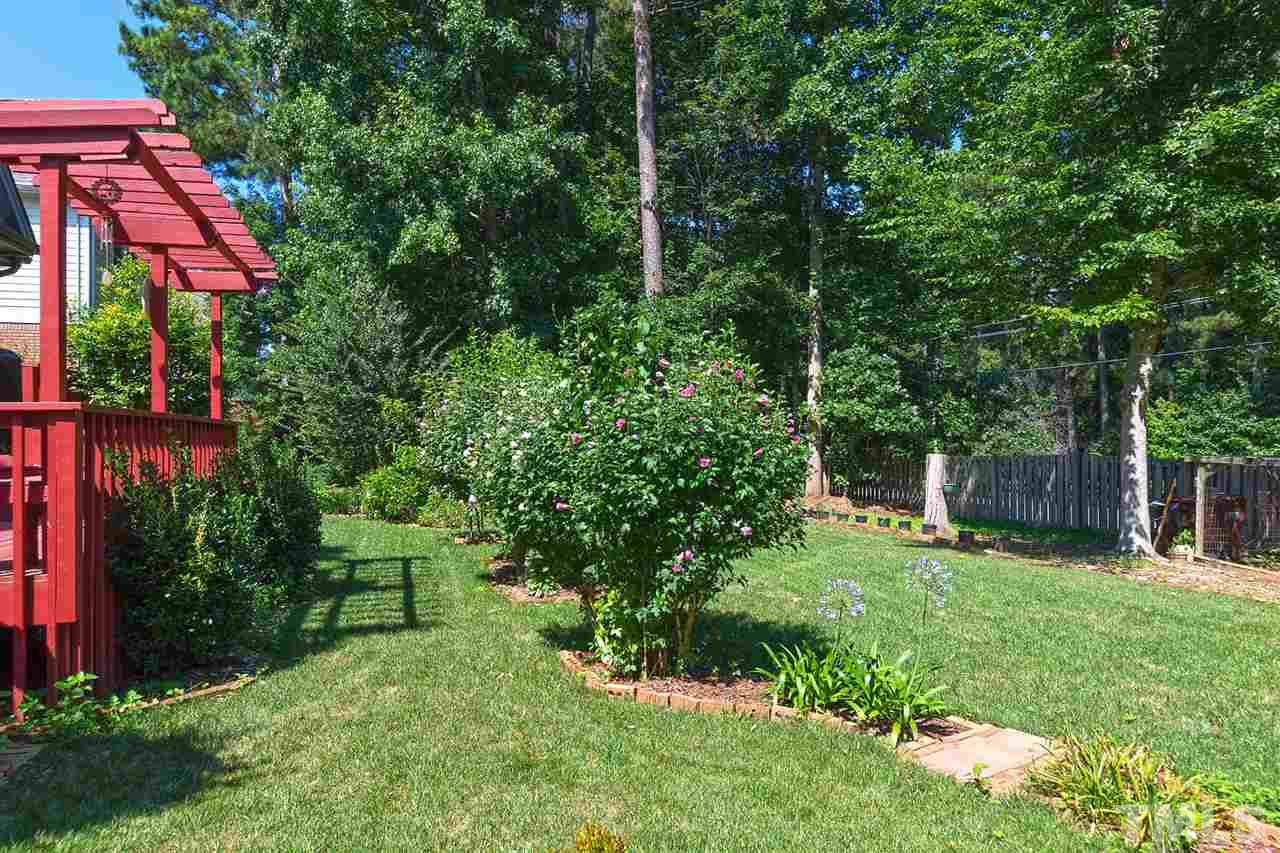 10108 Goodview Court Raleigh, NC 27613 - Photo 22 of 25 a view of a backyard with plants and brick wall