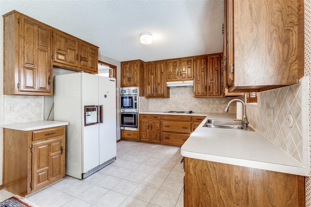 9121 Church Road Dallas, TX 75231 - Photo 3 of 13 a kitchen with stainless steel appliances granite countertop a sink stove and refrigerator