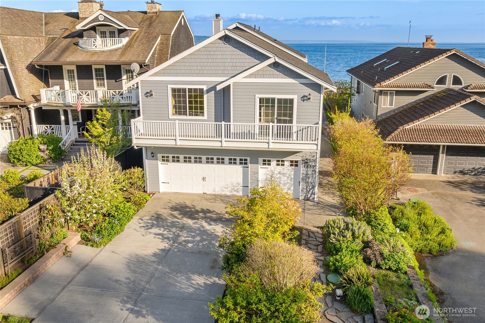 1882 Shore Avenue Freeland, WA 98249 - Photo 5 of 36 a view of a white house with large windows and flower plants
