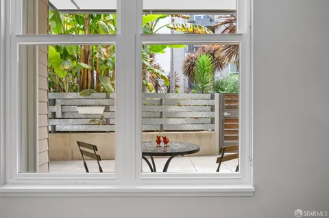 a porch with a chair and potted plant