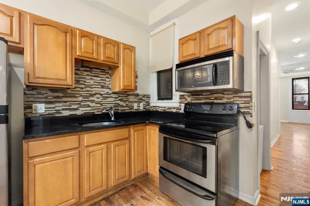 a kitchen with granite countertop cabinets stainless steel appliances and a sink
