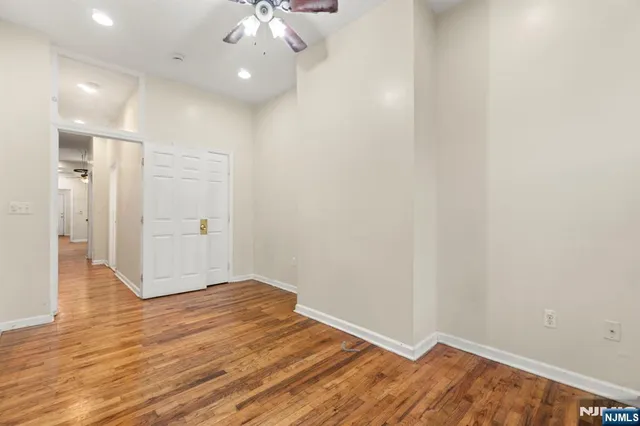 a view of an empty room with wooden floor