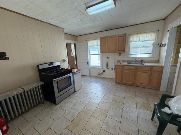 a kitchen with stainless steel appliances a stove a sink a counter top space and cabinets