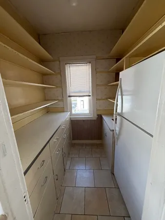 a kitchen with white cabinets and refrigerator