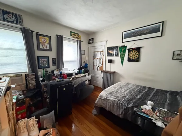 a bedroom with a bed window and dresser