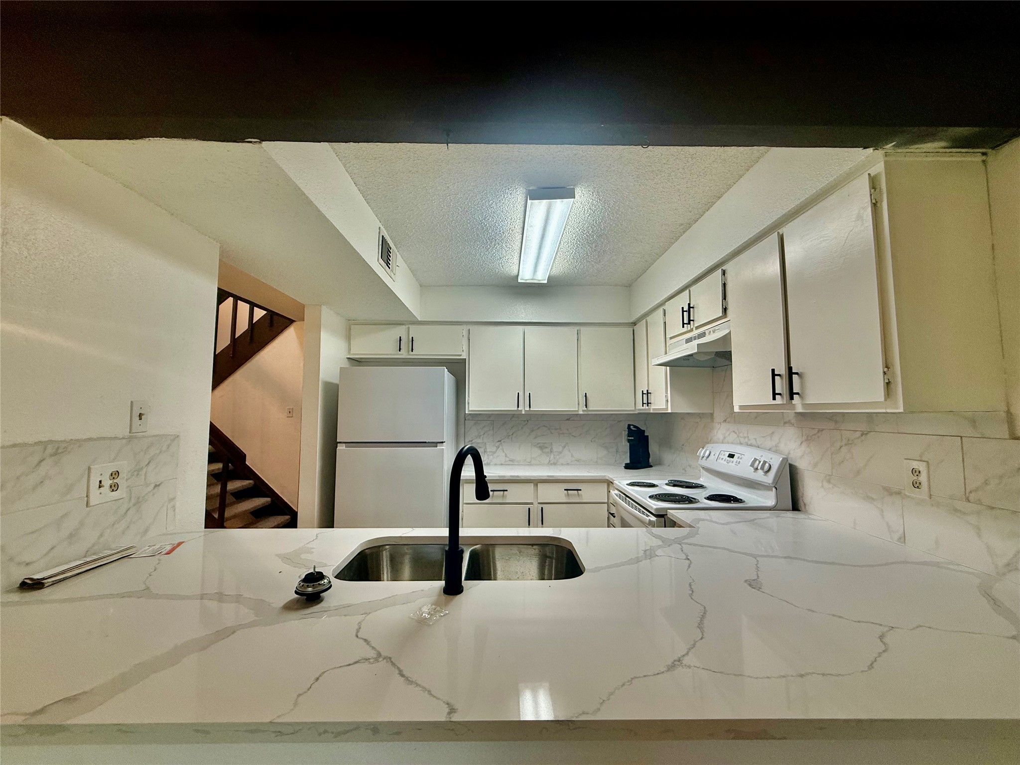 12922 Wirevine Lane Houston, TX 77072 - Photo 6 of 26 a kitchen with a sink a stove and cabinets