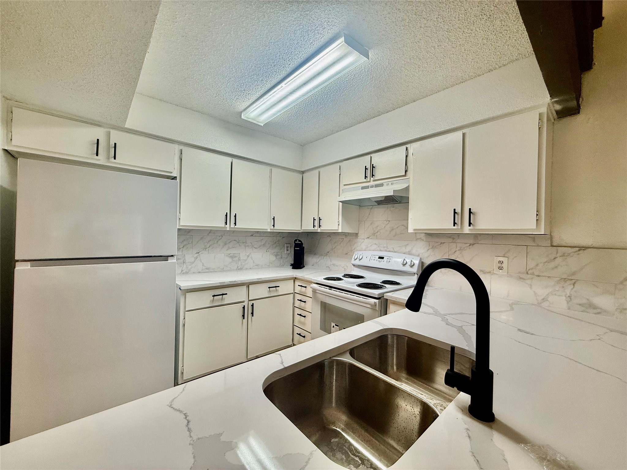 12922 Wirevine Lane Houston, TX 77072 - Photo 7 of 26 a kitchen with a refrigerator sink and white cabinets