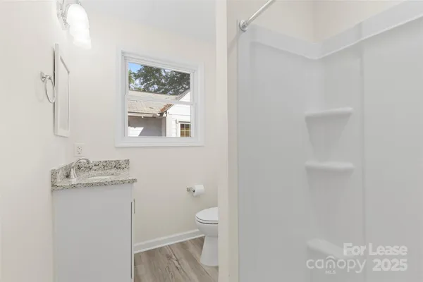 a view of a big room with wooden floor and windows