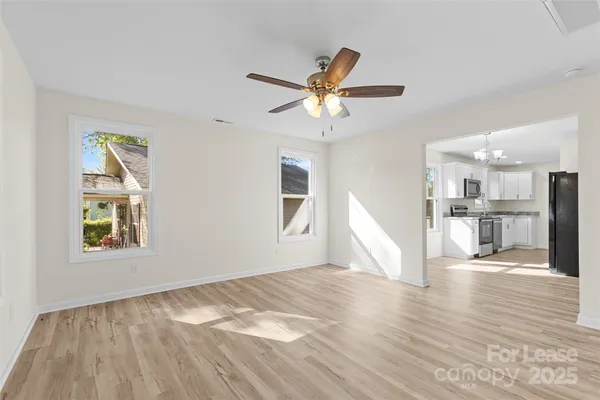 a view of a kitchen with wooden floor and windows