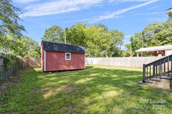 a view of a house with a yard and a wooden deck