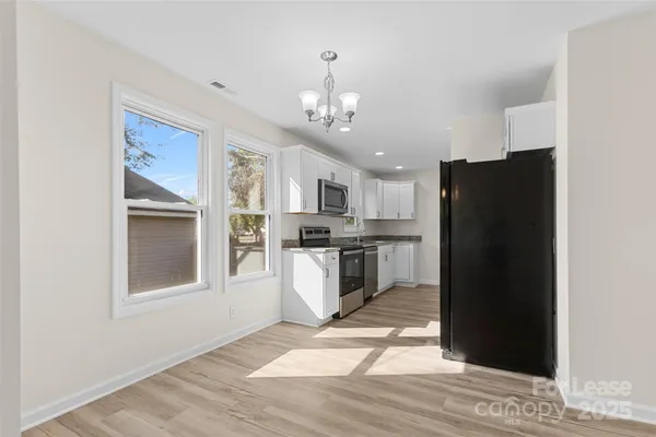 a kitchen with stainless steel appliances granite countertop a refrigerator and a stove top oven