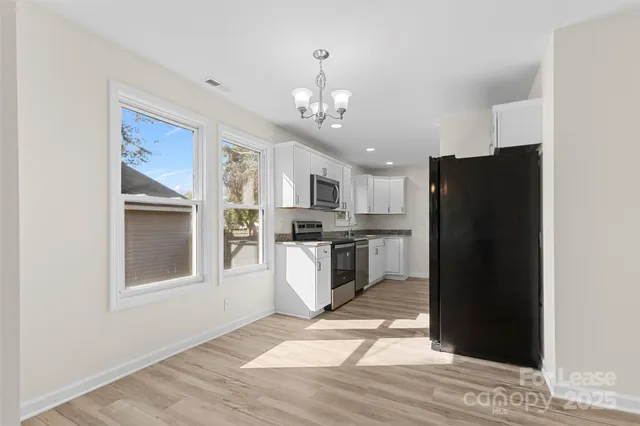 a kitchen with stainless steel appliances granite countertop a refrigerator and a stove top oven