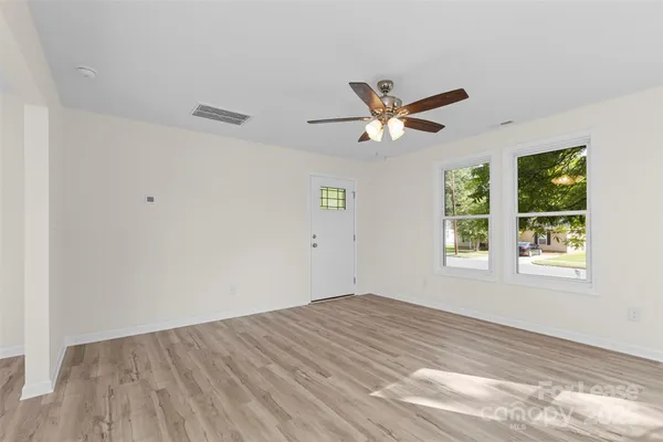 a kitchen with stainless steel appliances granite countertop a stove top oven a refrigerator and a sink with wooden floor