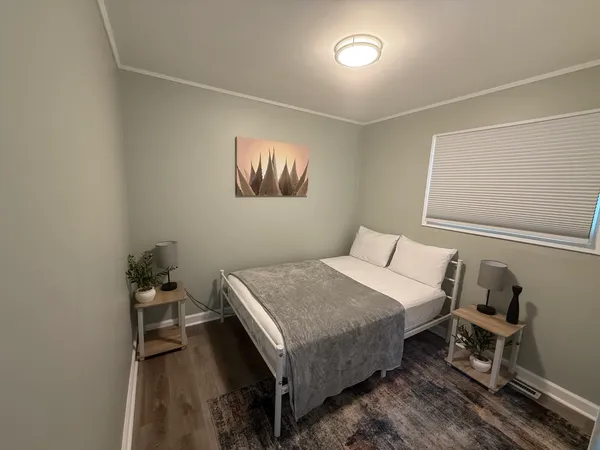 a bedroom with a bed and wooden floor