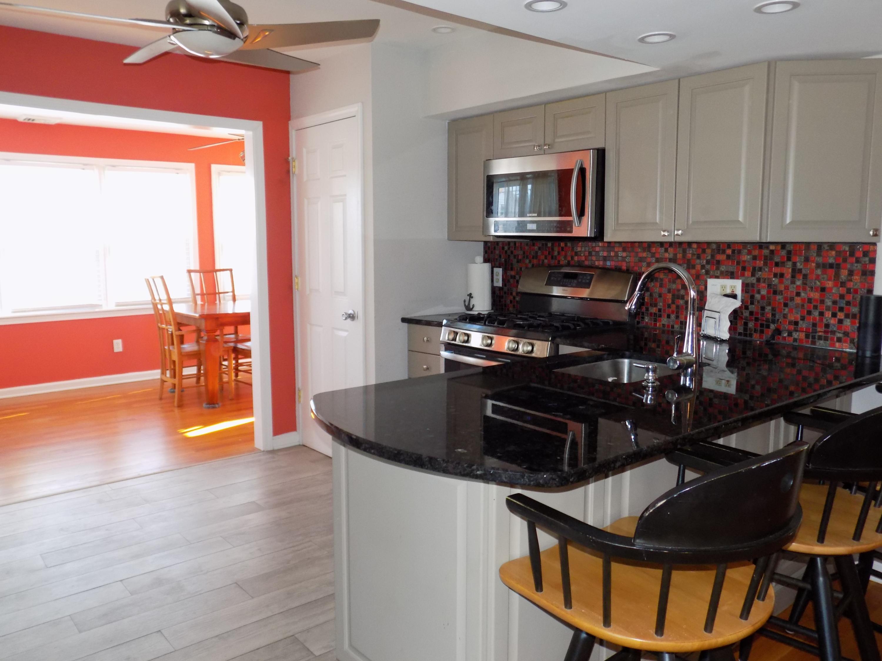 116 Gary Road Toms River, NJ 08753 - Photo 13 of 42 a kitchen with granite countertop a stove a sink and a dining table with wooden floor