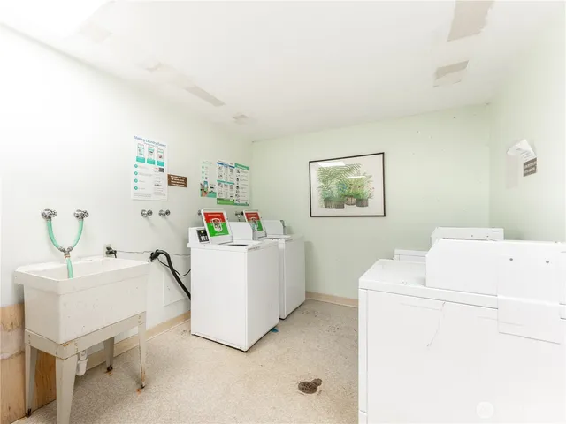 a living room with furniture and a refrigerator