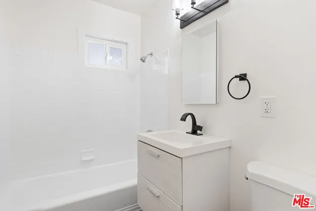 a kitchen with stainless steel appliances granite countertop a sink a counter space and a window