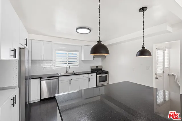 a kitchen with stainless steel appliances granite countertop a sink stove and refrigerator