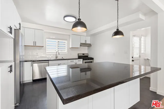a kitchen with white cabinets and appliances