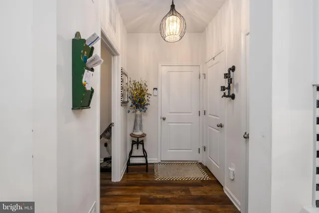 a view of a hallway with wooden floor and entryway