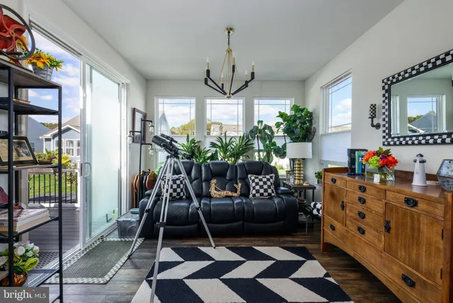 a living room with furniture a flat screen tv and a floor to ceiling window