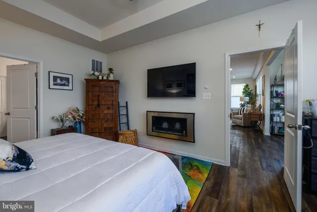 a bedroom with a bed a flat screen tv and a fireplace