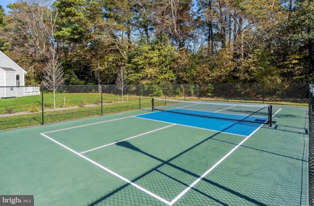 a view of tennis court with wooden fence