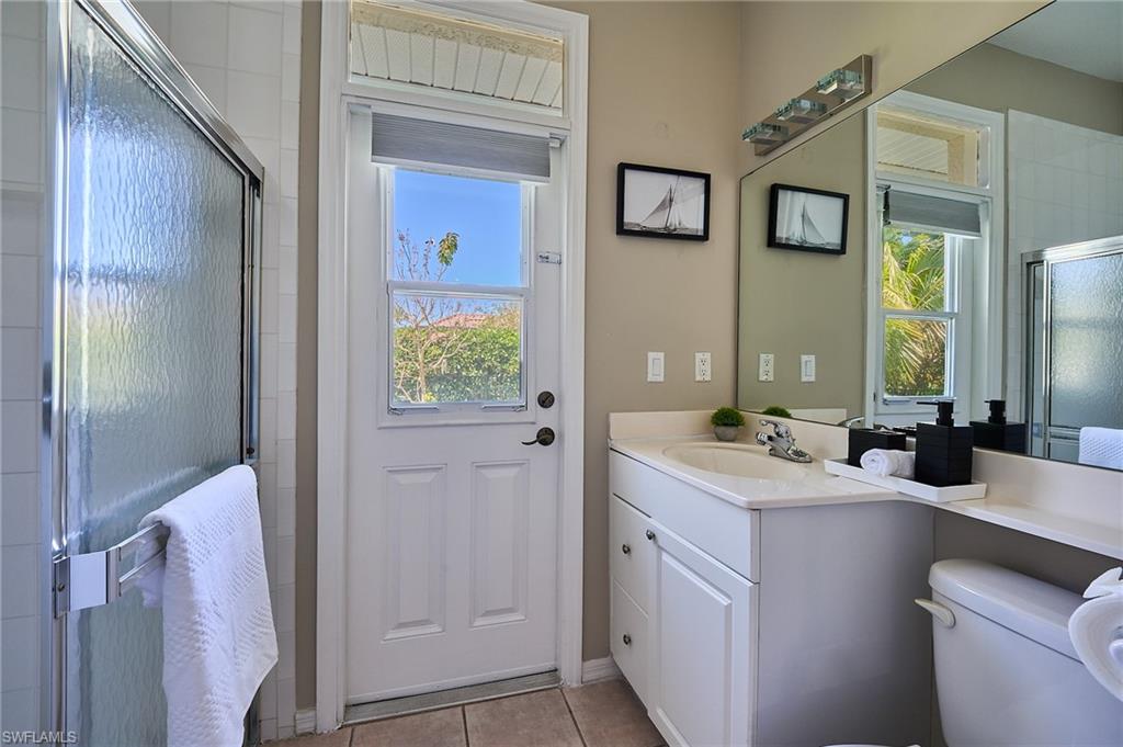 186 Muirfield Circle Naples, FL 34113 - Photo 21 of 36 a bathroom with a sink a toilet and mirror