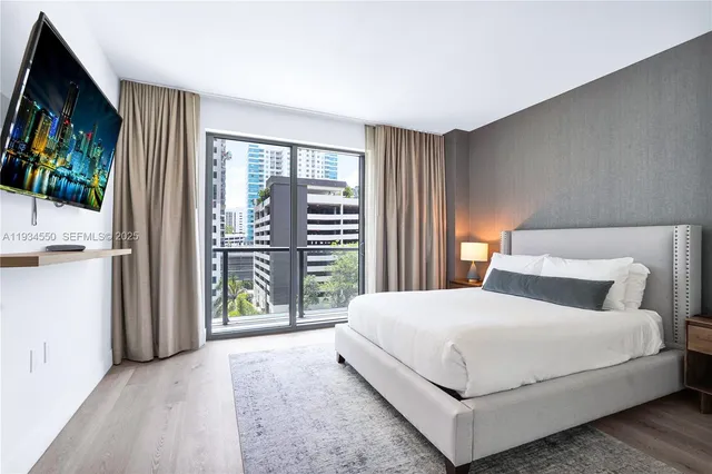 a large bedroom with a bed and large window