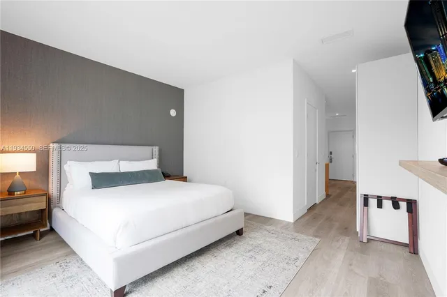 a bedroom with a bed and a flat screen tv