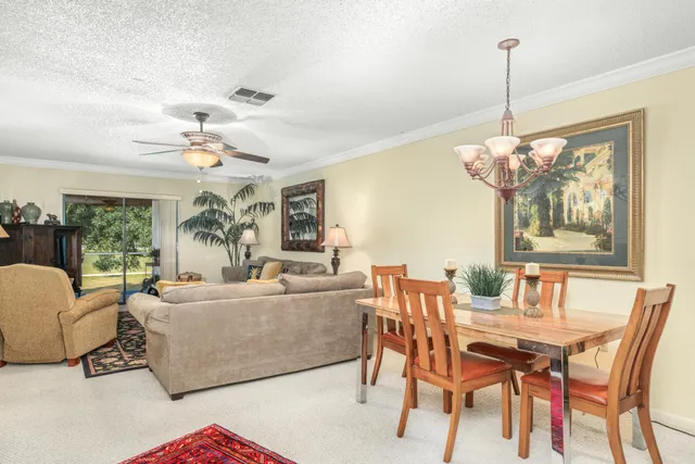 a living room with furniture a chandelier and a table