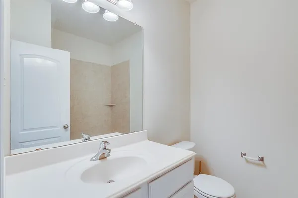 a bathroom with a sink a toilet and mirror
