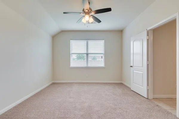 an empty room with a window and a fan